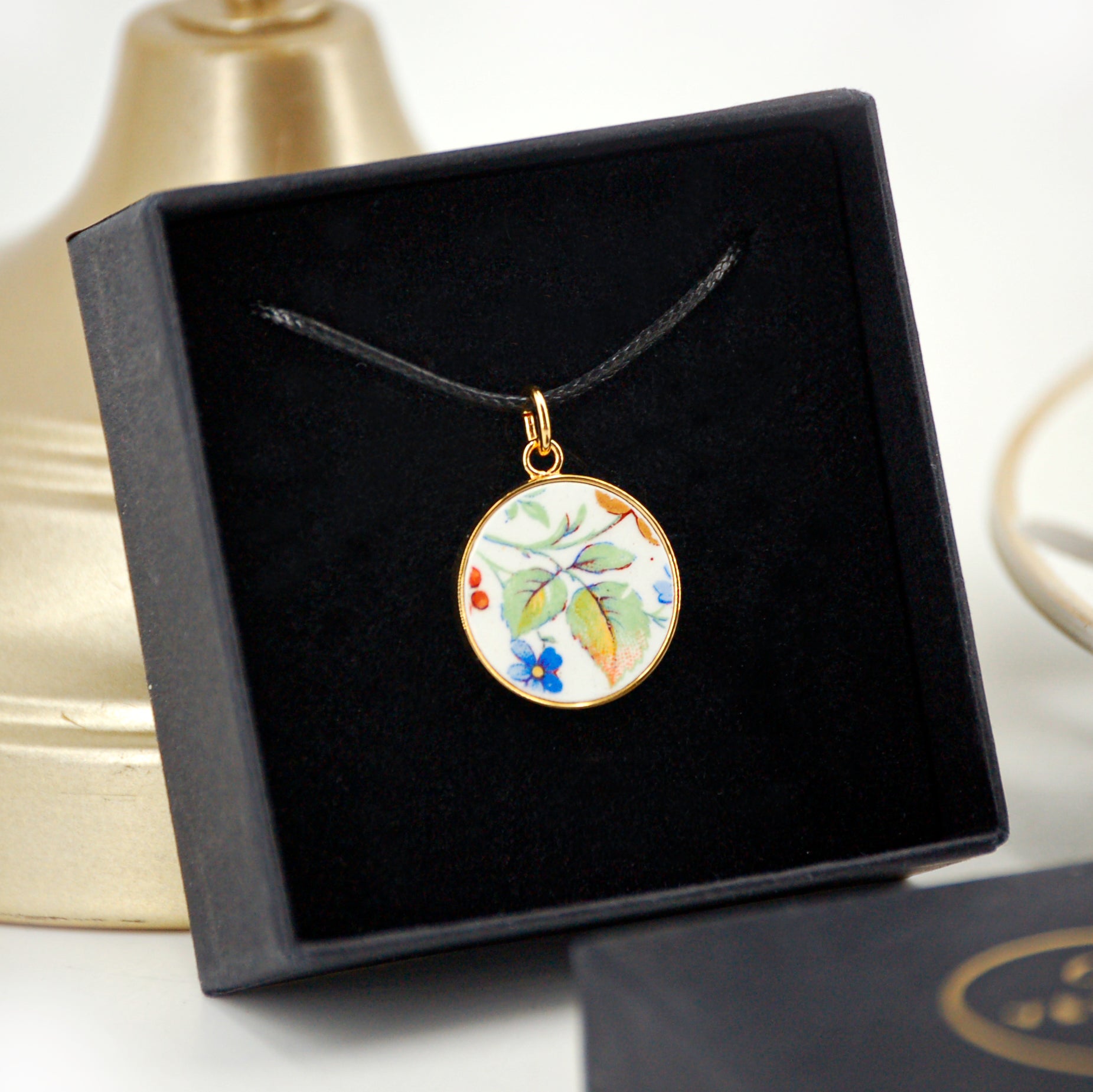 Pendentif "Feuilles vertes et petite fleur bleue"
