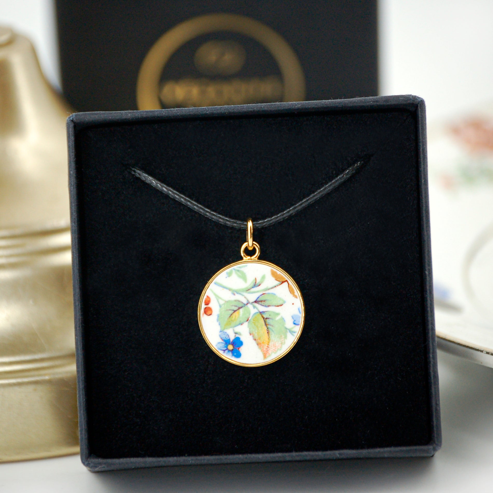 Pendentif "Feuilles vertes et petite fleur bleue"