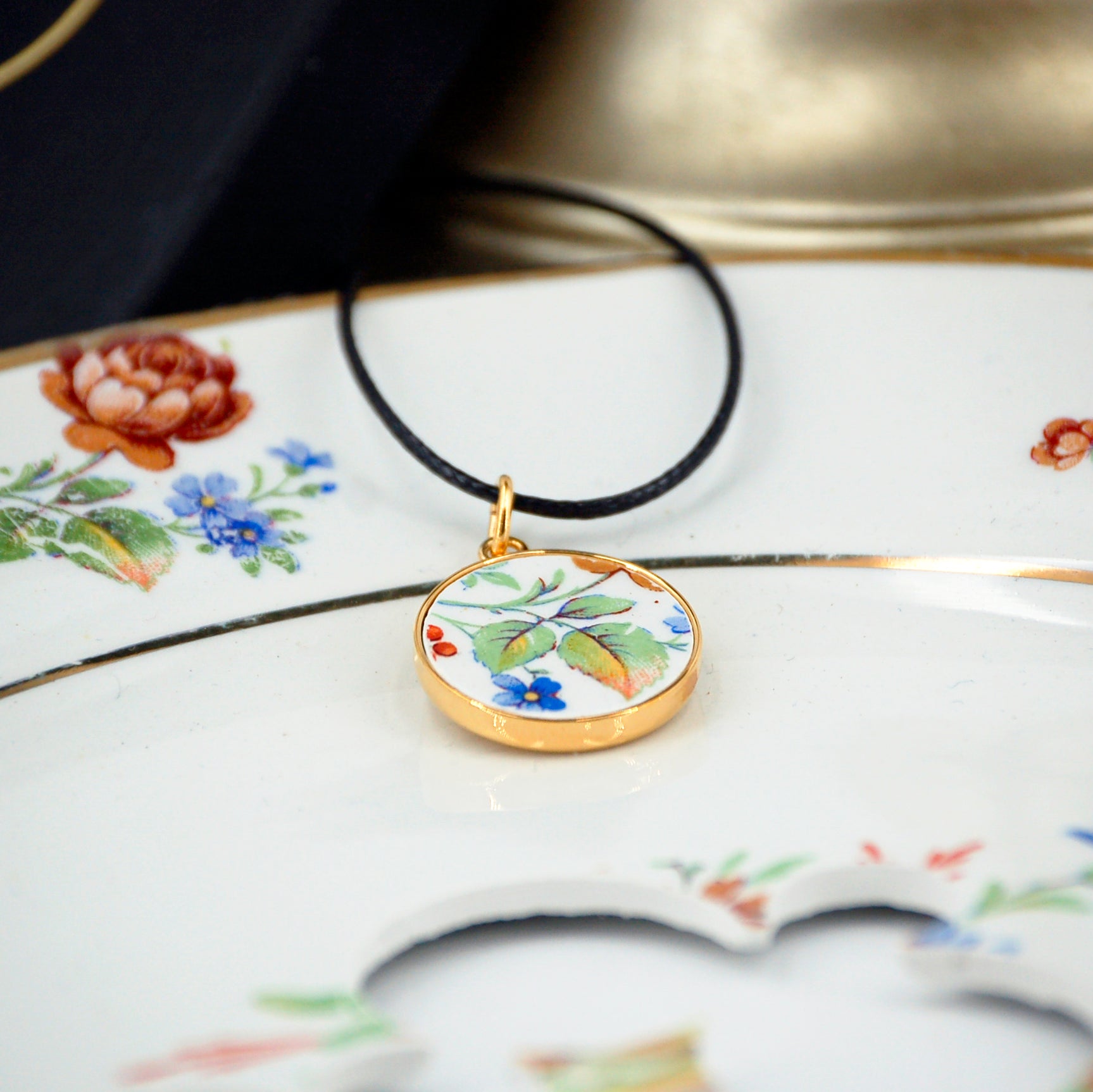 Pendentif "Feuilles vertes et petite fleur bleue"