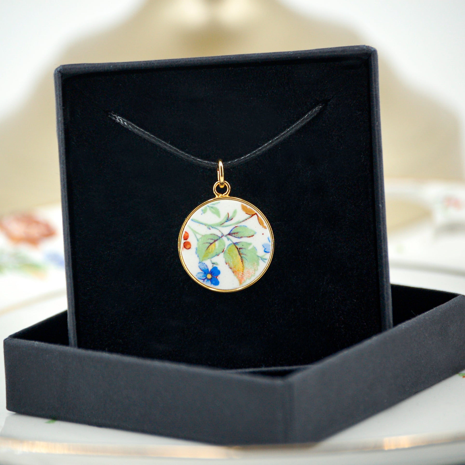 Pendentif "Feuilles vertes et petite fleur bleue"