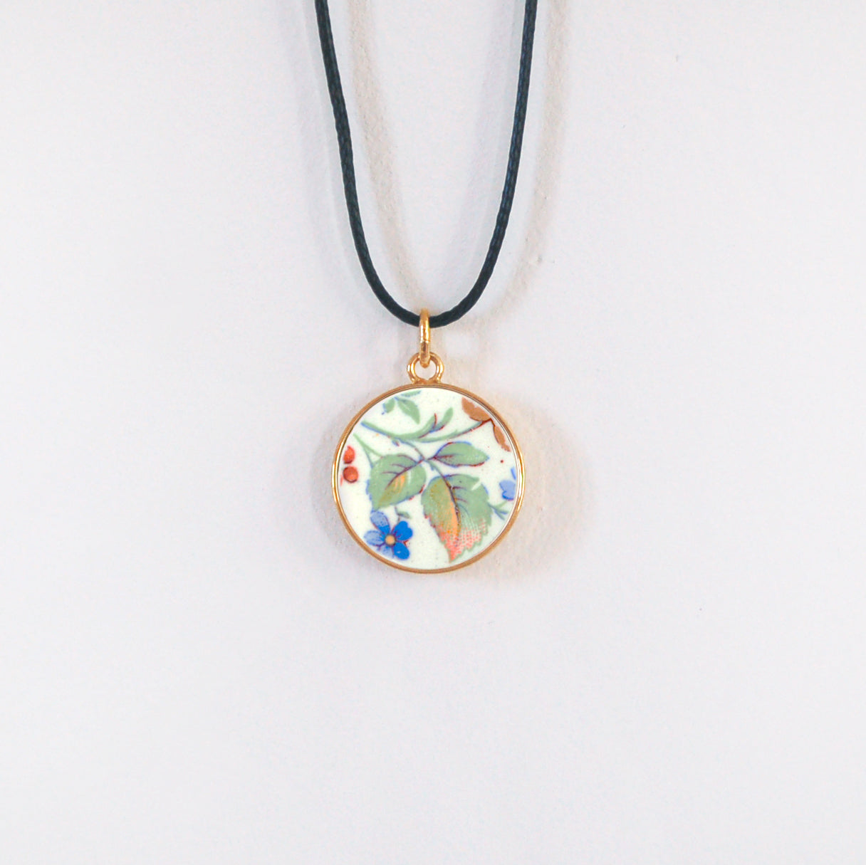 Pendentif "Feuilles vertes et petite fleur bleue"